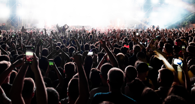 Fotografia de aglomeração de pessoas em frente a palco de show