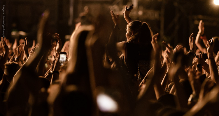 Fotografia de pessoas dançando em frente a palco