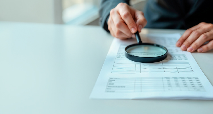 Imagem de lente de aumento em frente a papel com gráficos