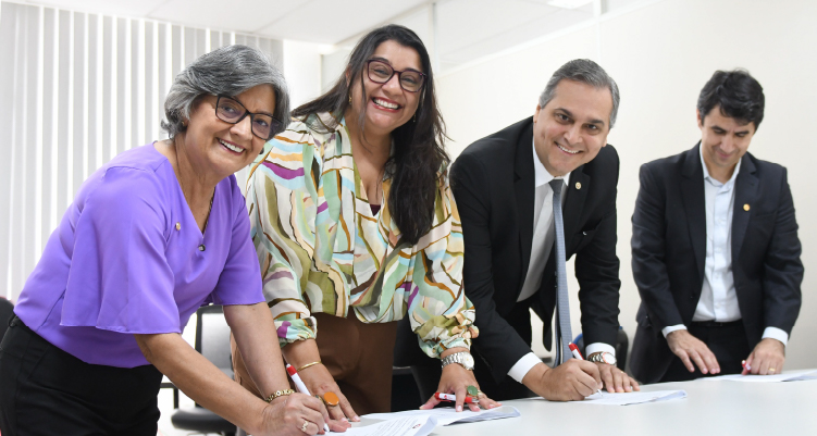 momento em que participantes da reunião assinam documento de compromisso