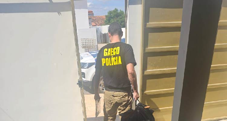 Fotografia de agente saindo com malote de material apreendido