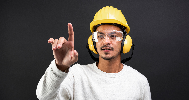 Foto de um homem utilizando equipamentos de proteção, como capacete, fone de ouvido e óculos.